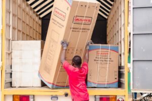 Worker loading an old appliance onto a truck for appliance removal in Dubai