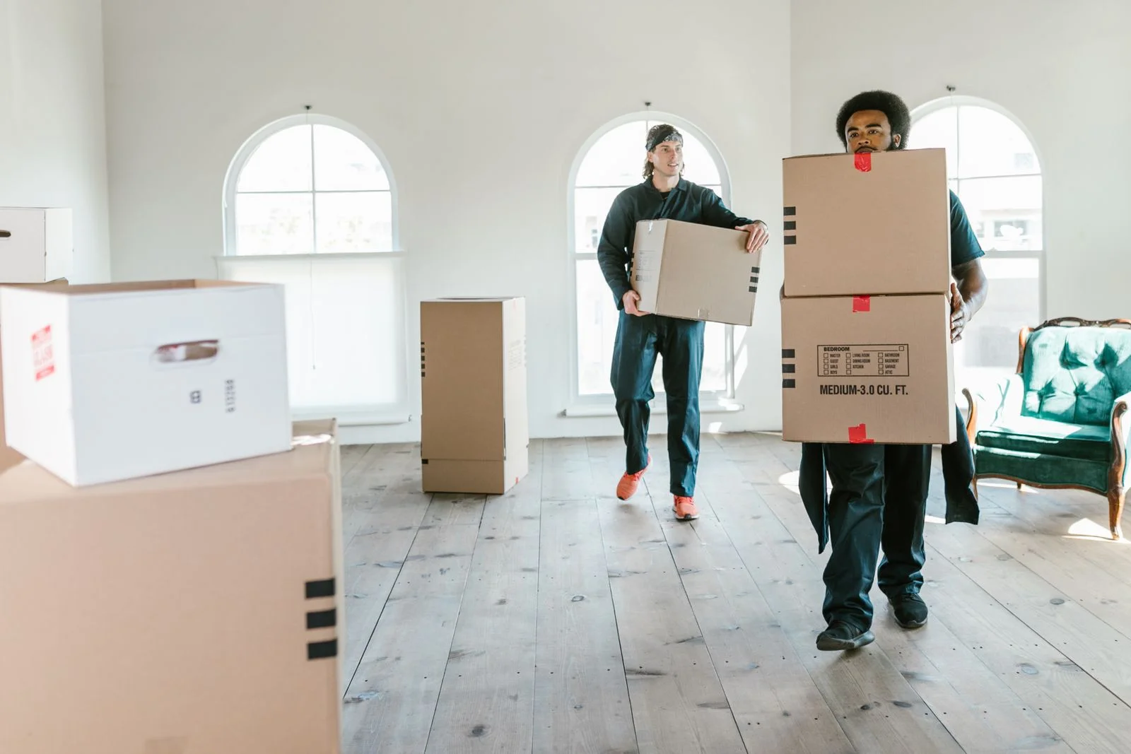 Junk removal team carrying boxes and unwanted items out of a Dubai apartment