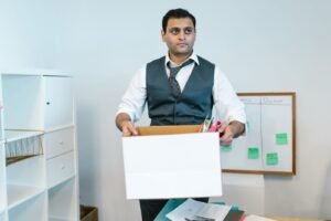 Professional carrying out an office cleanout in Dubai, packing workspace items into a box