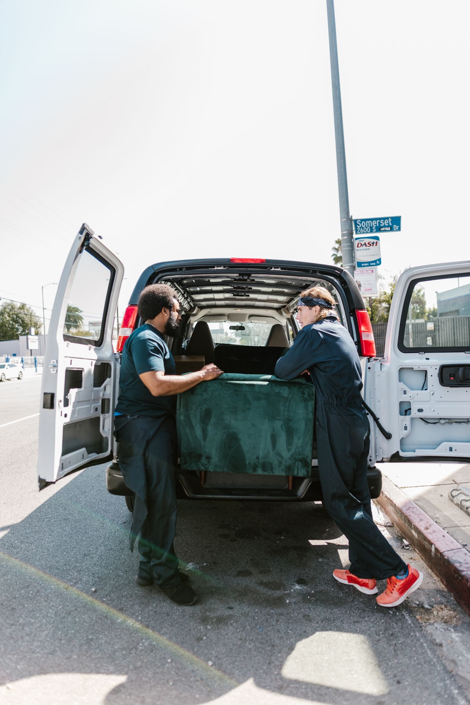Movers loading furniture into a van during a same-day collection in Dubai